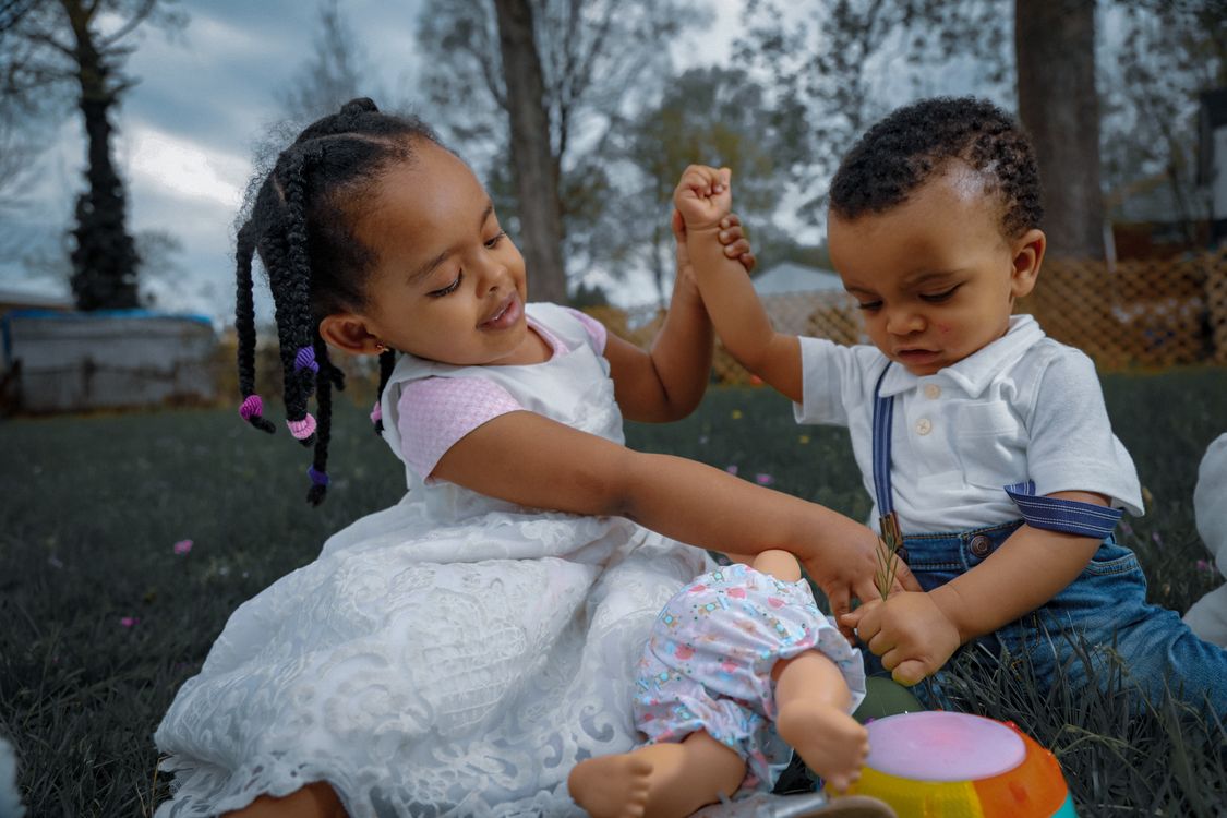 Two children playing together outside in the sunshine