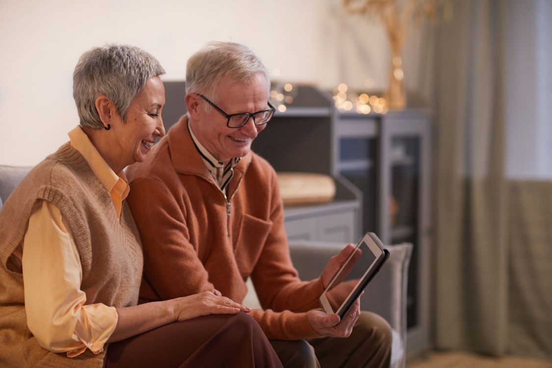 Grandparents on a video call with their family using a tablet