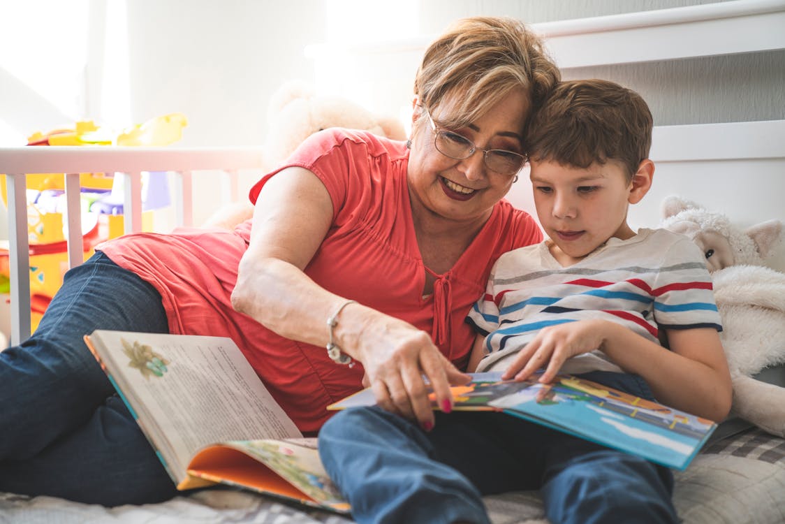 Grandmother reading aloud to two children from a book