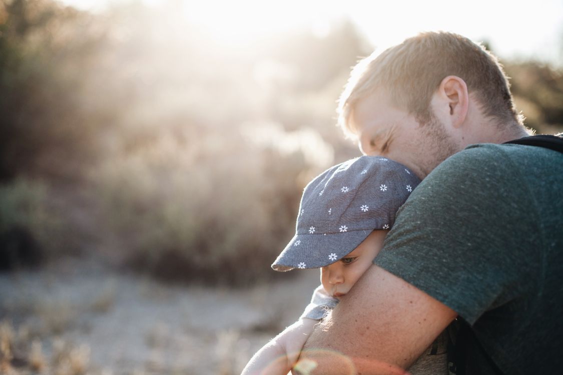 A father holding his baby outdoors