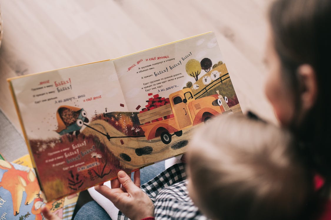 Mother reading an illustrated book to her toddler