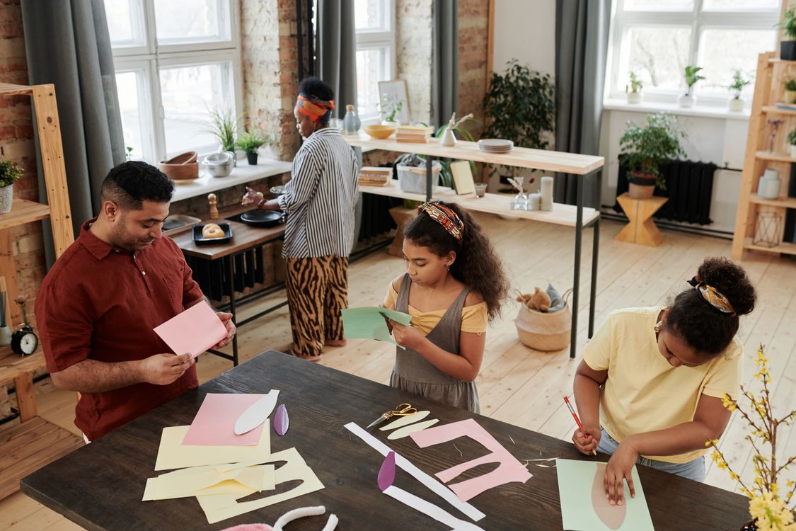 A parent and child making something together at a table