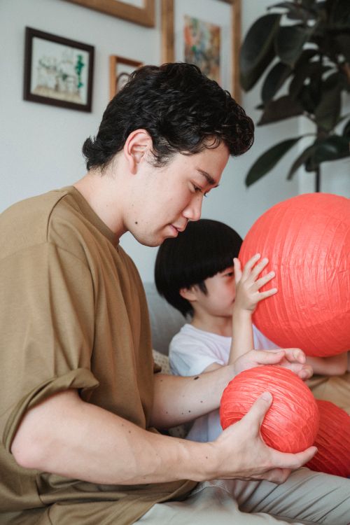 A father and child proudly holding something they made themselves