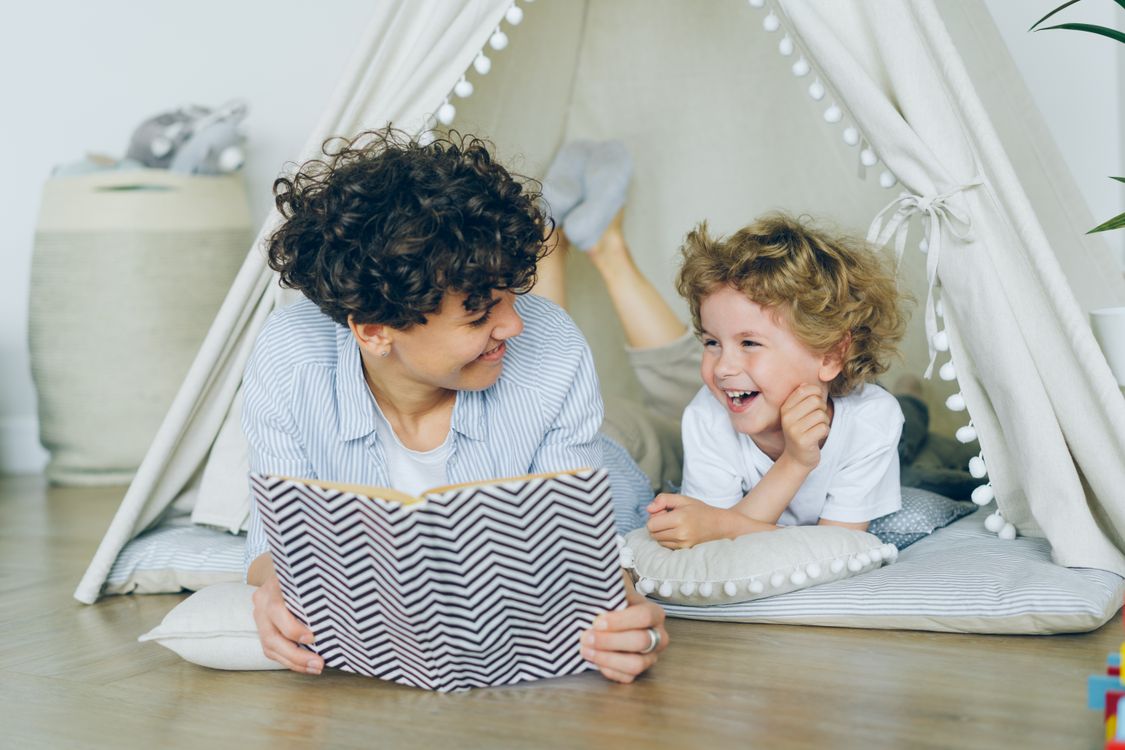 Mother and child reading together in a cosy reading nook