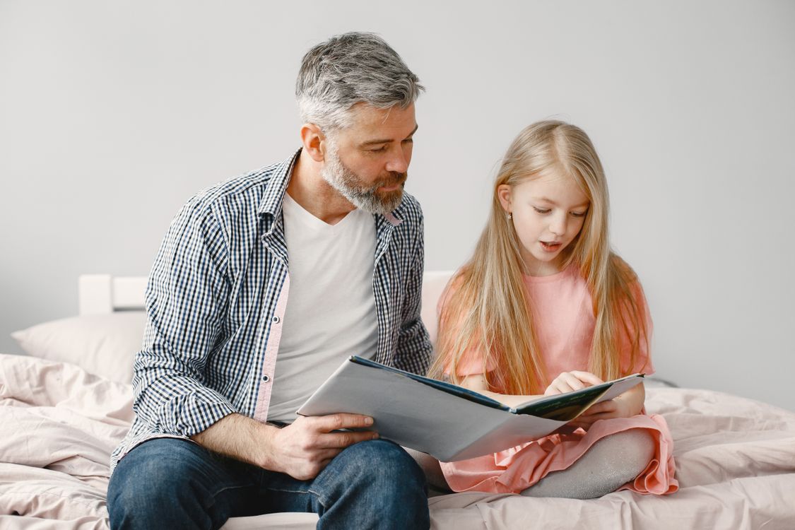 Father reads a bedtime story to his daughter