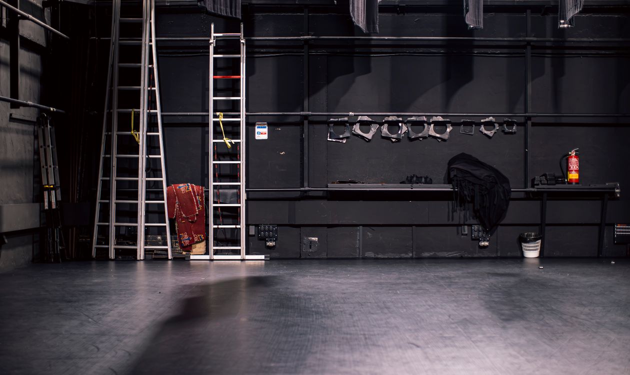 An empty stage with ladders and lights, ready for the show