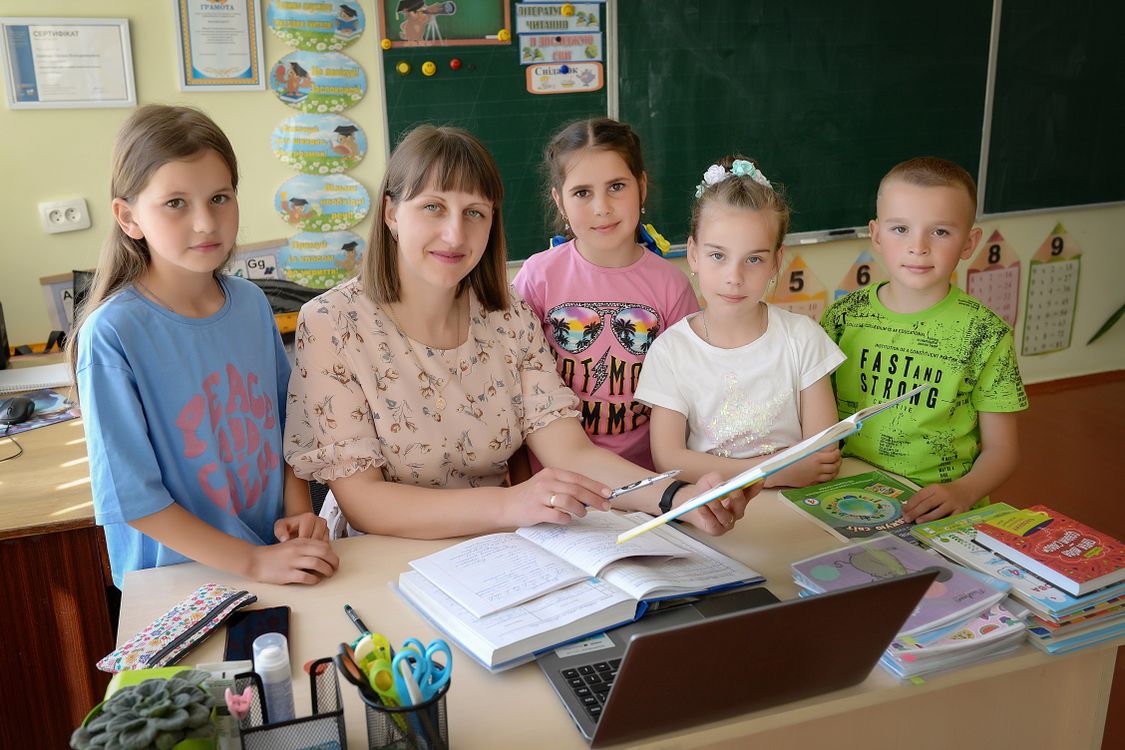 Children in a classroom listening attentively to their teacher