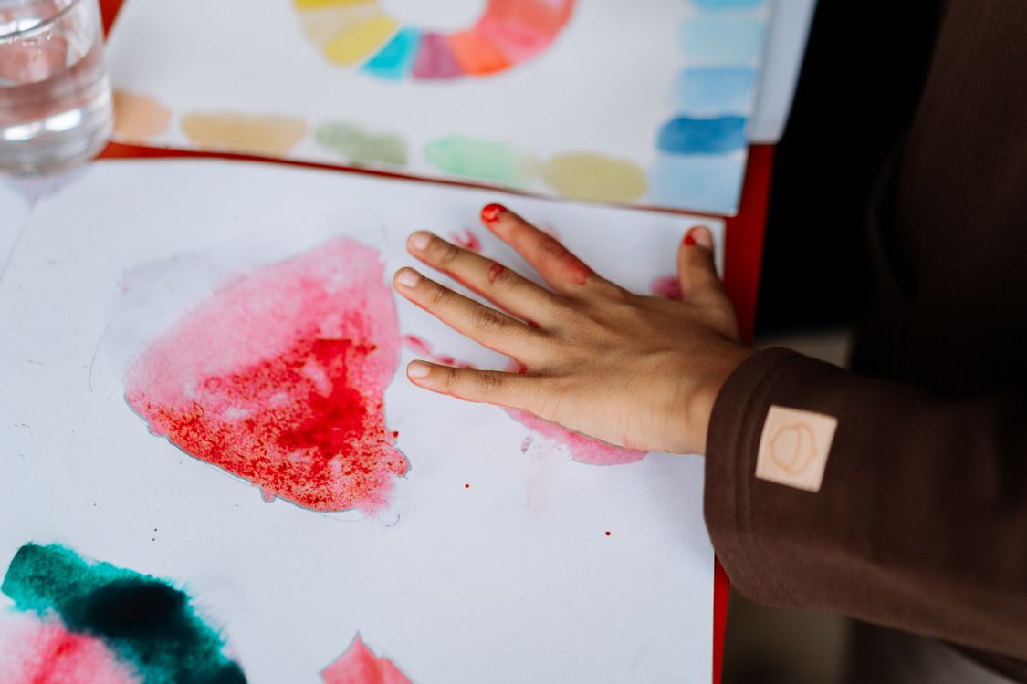 A child painting with watercolours, symbolising the creativity behind personalisation