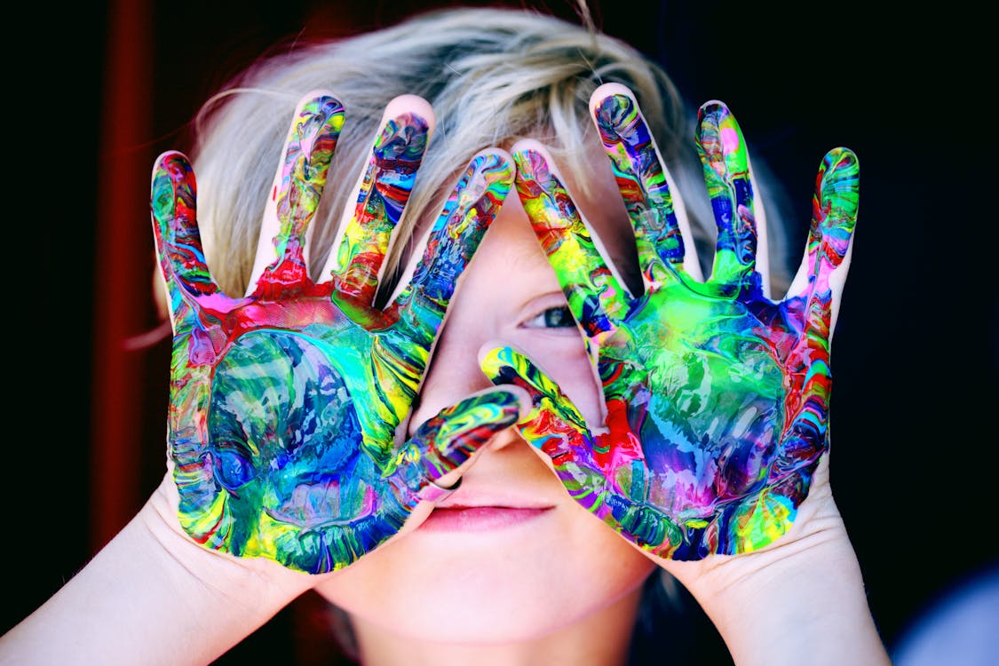 Child with paint-covered hands symbolising original creativity