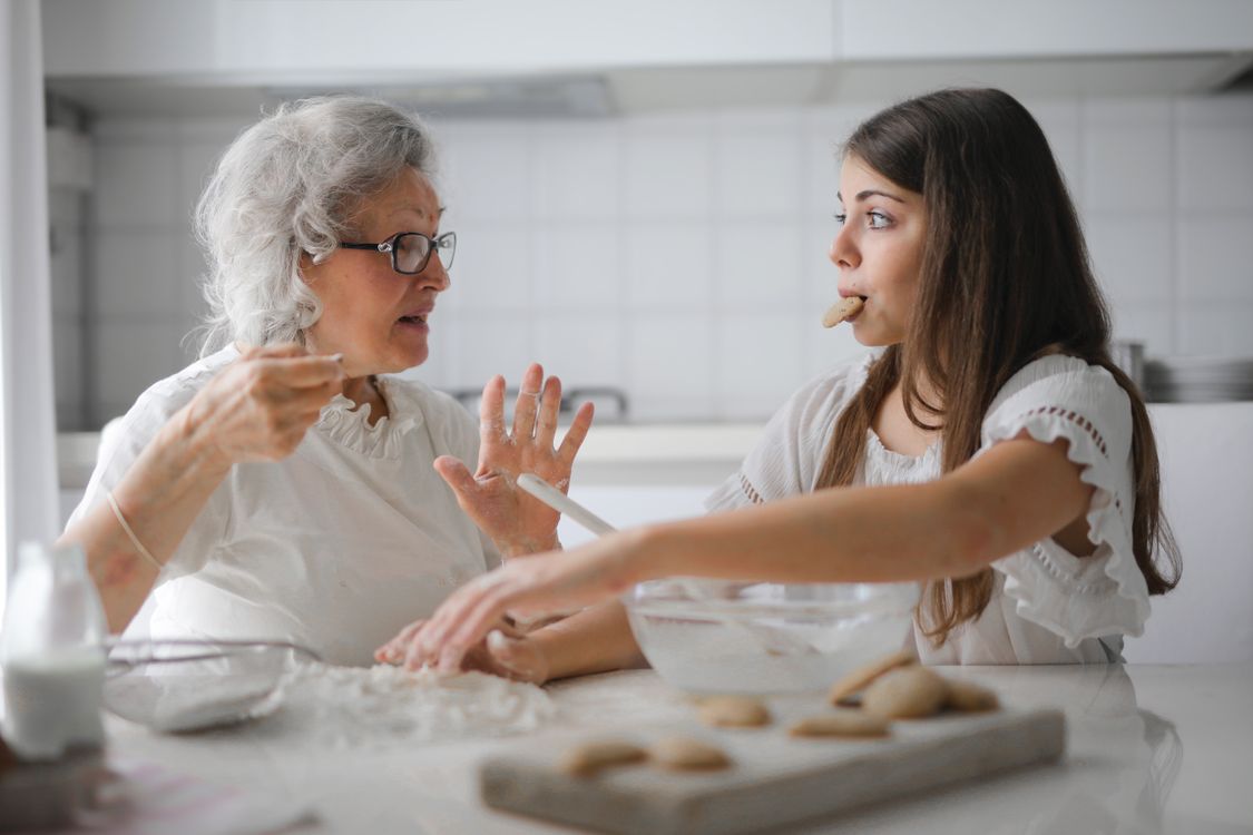 Grandmother and granddaughter talking in the kitchen