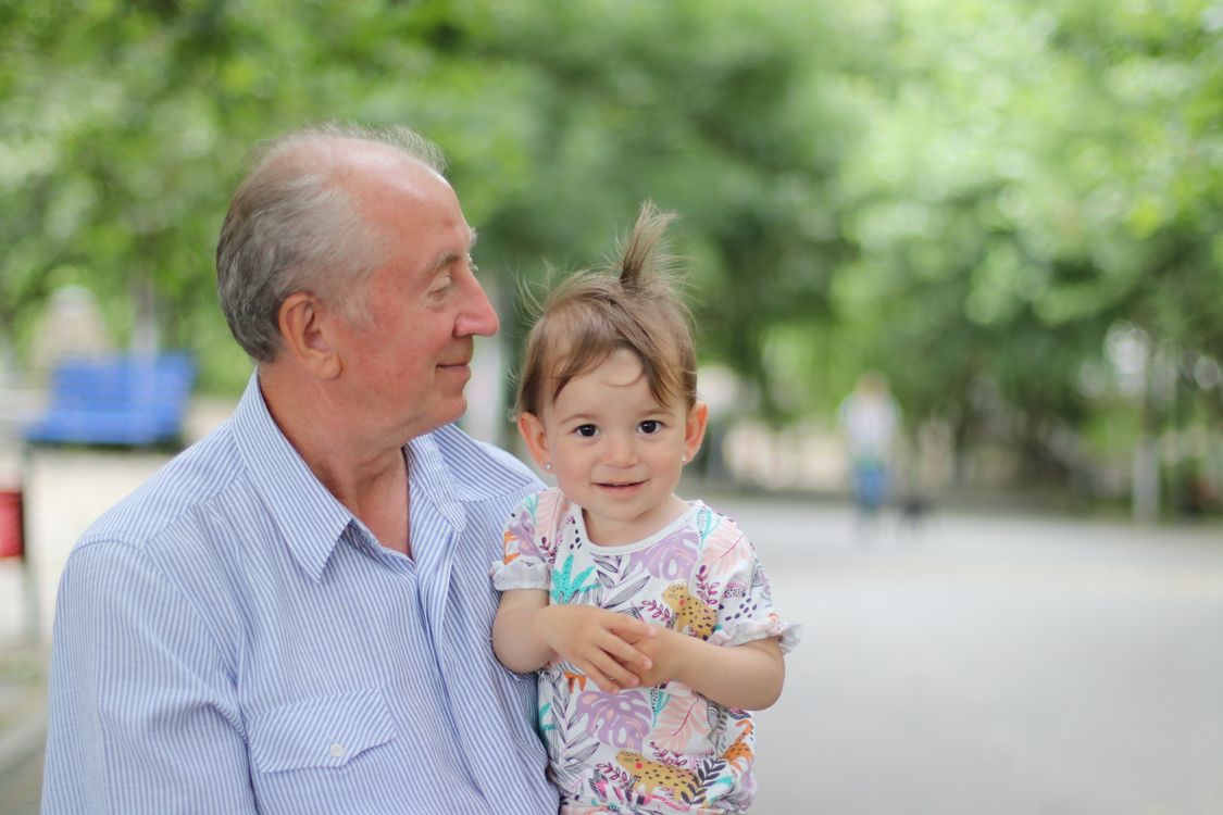 Grandfather holding his grandchild in the park