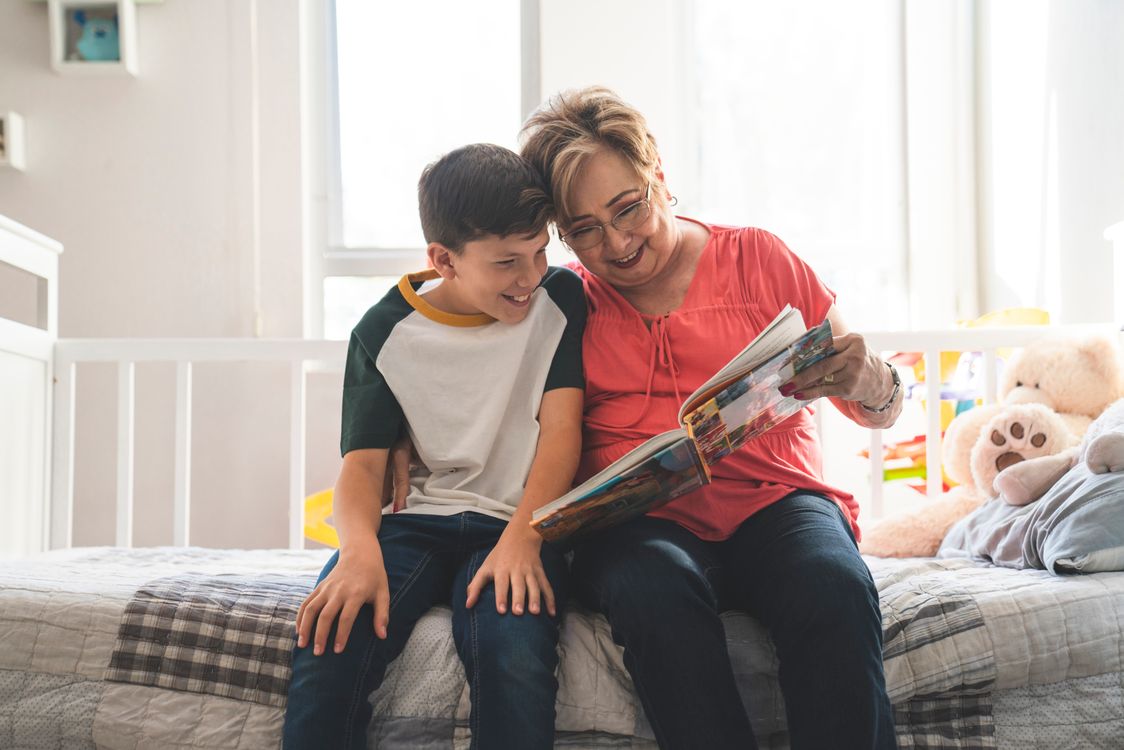 A grandmother reads with her grandson - repeated reading of the same book builds vocabulary more reliably than varied titles