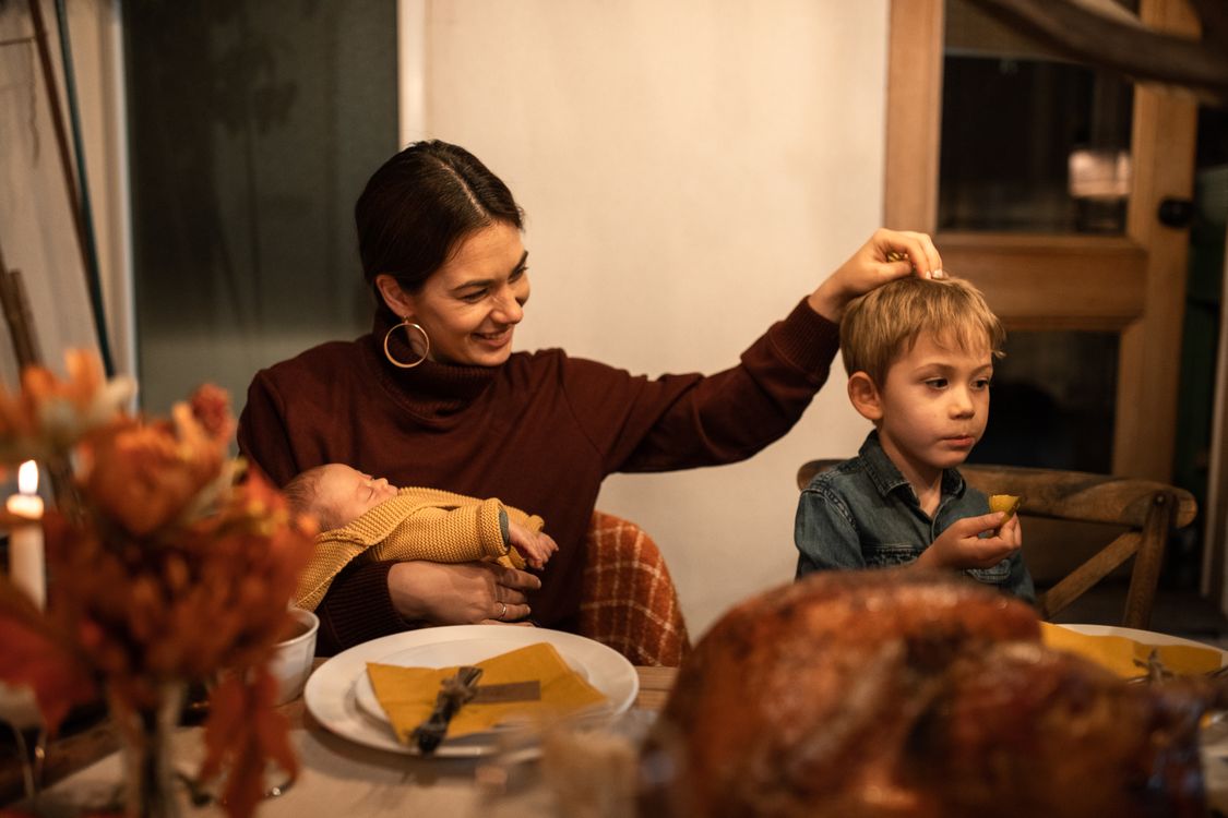A mother and her children at a warmly lit Thanksgiving dinner