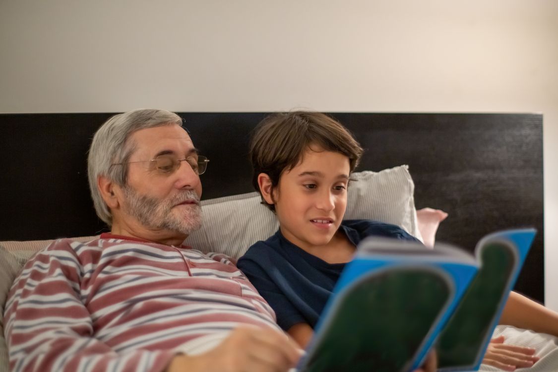 Grandfather and grandchild looking at a book together