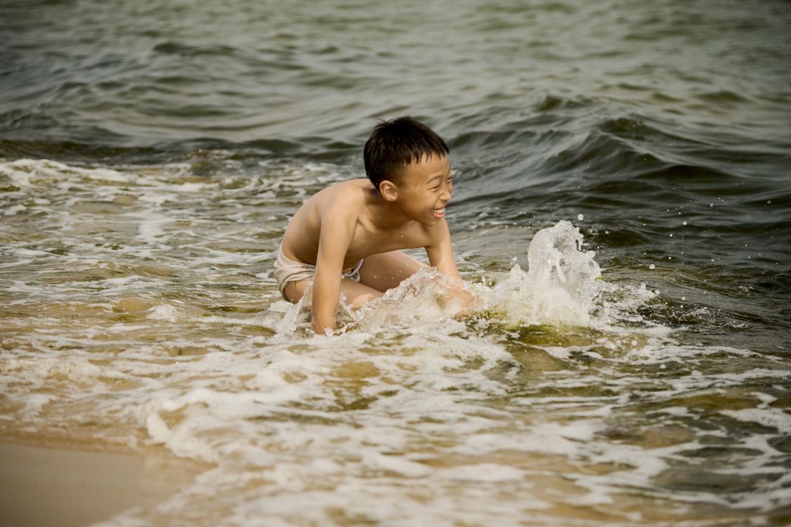 Child playing happily on the beach in the sun