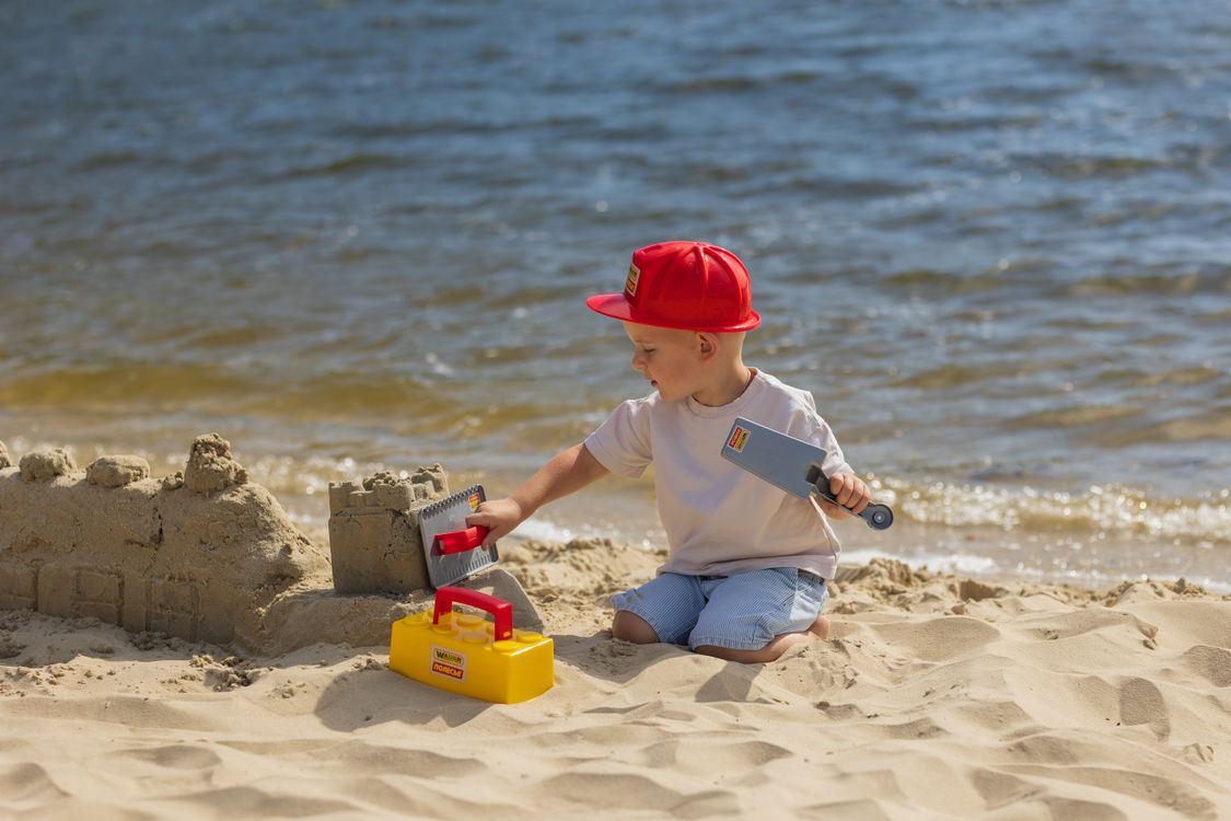 Young boy building a sandcastle on the beach, a classic holiday memory to look back on together