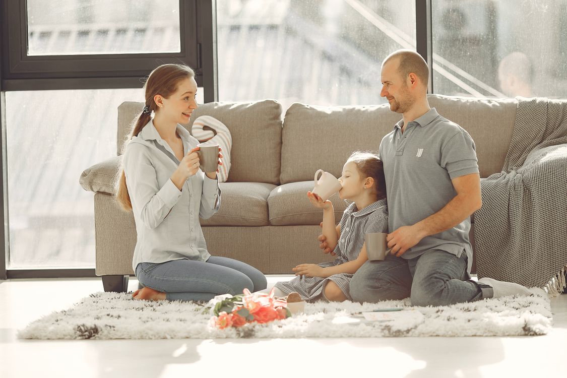 Family laughing together on the sofa at home, the moment holiday memories are shared