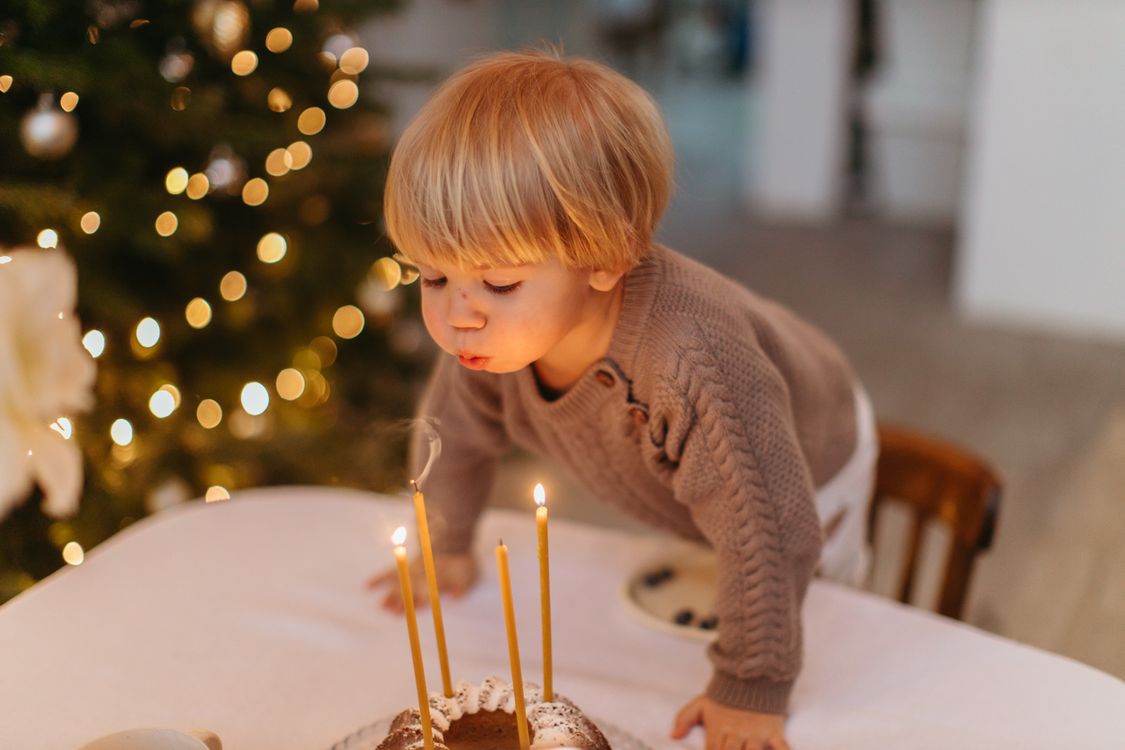 A child blowing out the candles on a birthday cake