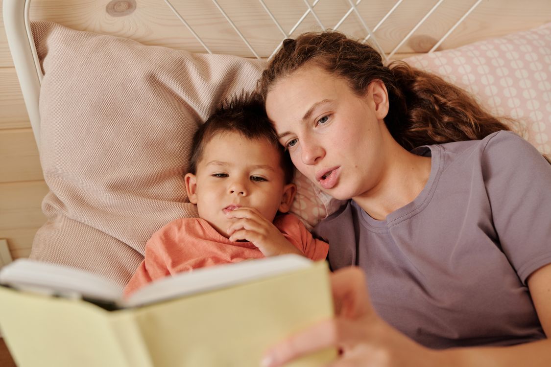 Parent reading a familiar bedtime story to a child in a cosy bedroom
