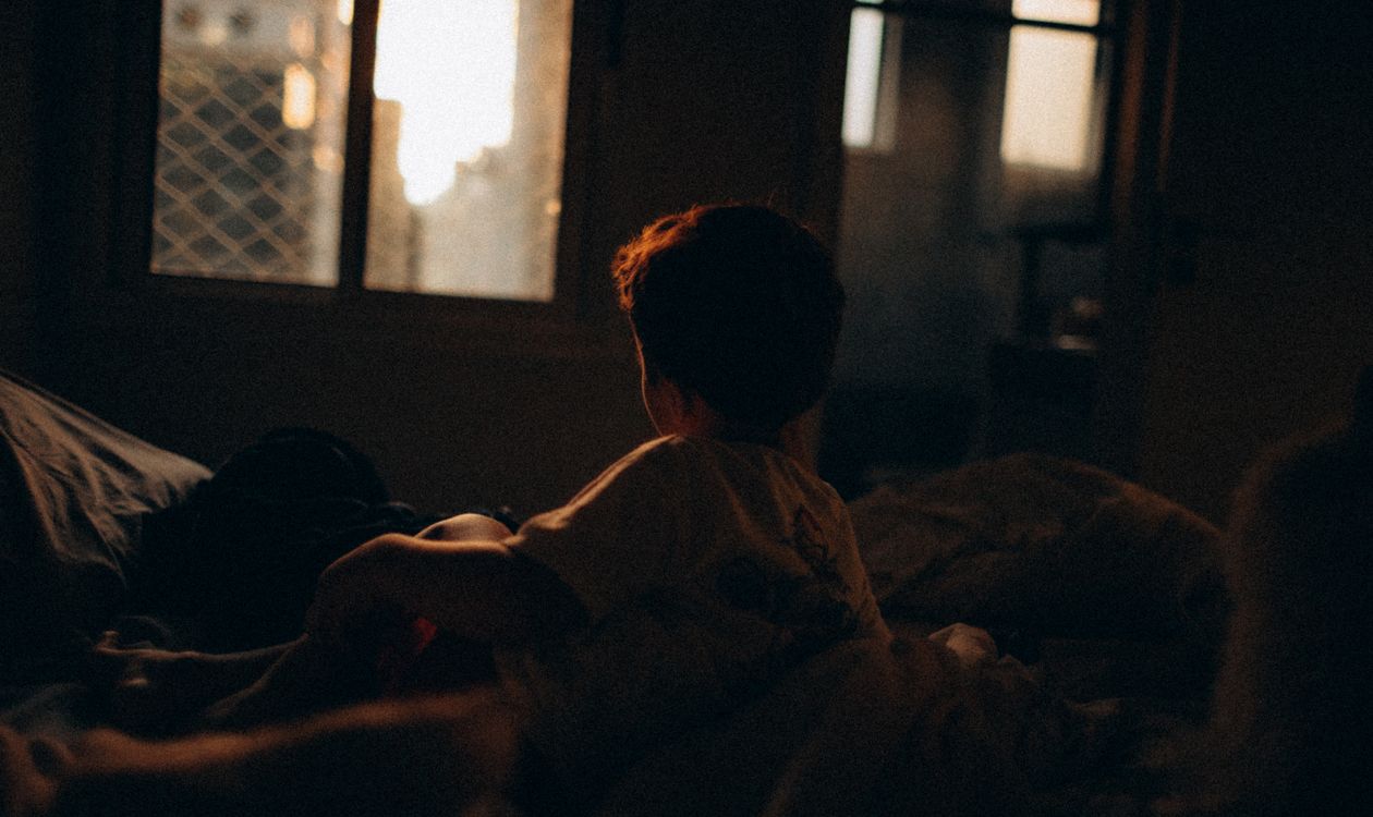 A child in the dark by the window, as the evening draws in early
